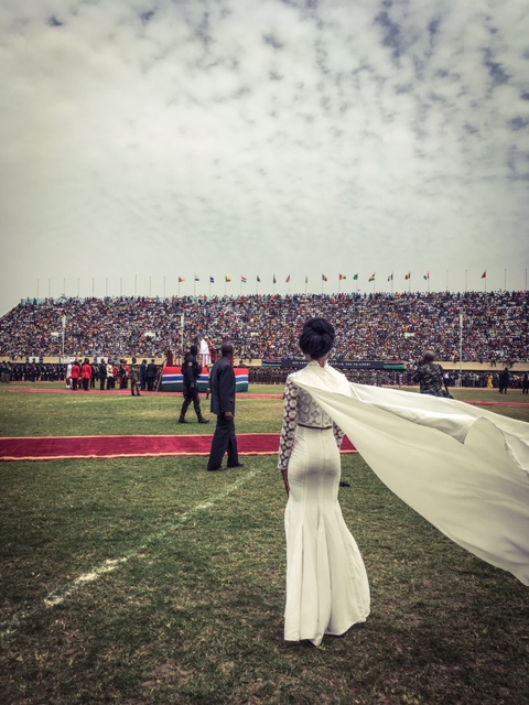 A female singer watches President Barrow being sworn in, as she waits to sing the Gambian National Anthem, Bakau Stadium © Helen Jones-Florio