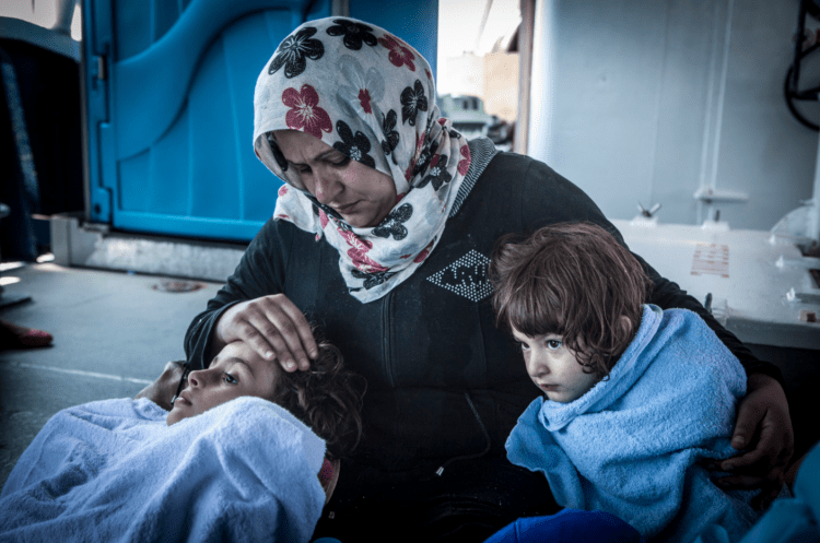 Fatima from Daraa, Syria traveling with only with her five young children comforts her 5-year-old twins, Ines and Imed, post-rescue © Jason Florio