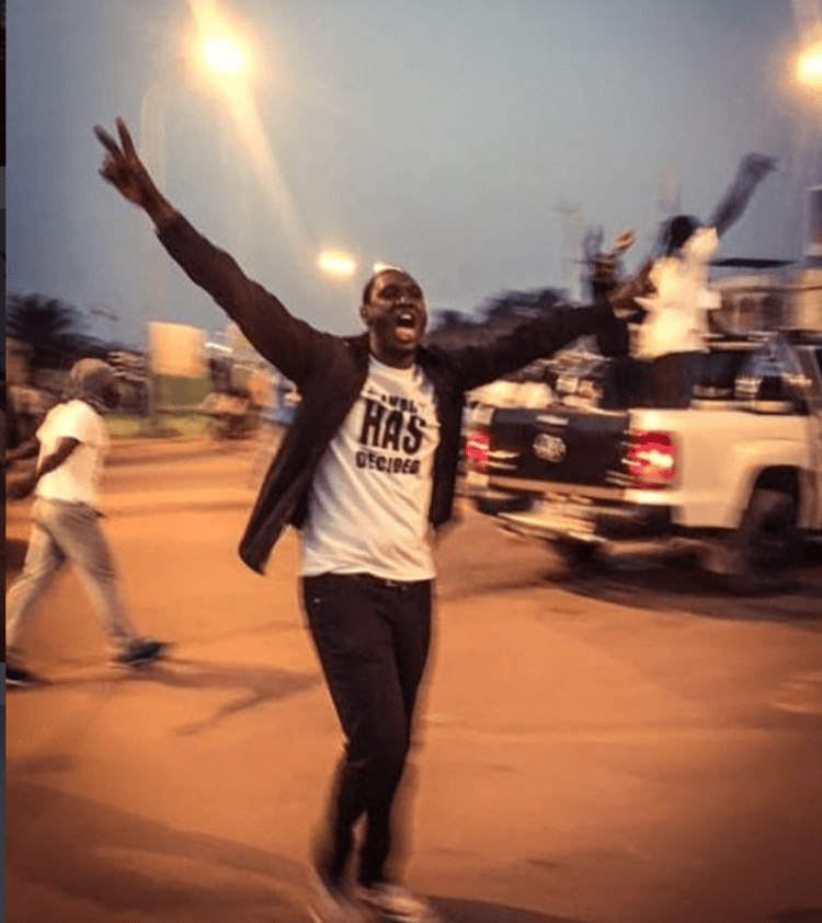 A young Gambian man raises the Victory sign, in celebration of the new president, Adama Barrow, Westfields, The Gambia © Helen Jones-Florio