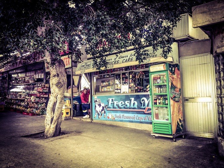 Men sitting outside of an old store front, bus station, Valletta (no longer there), Malta ©Helen Jones-Florio