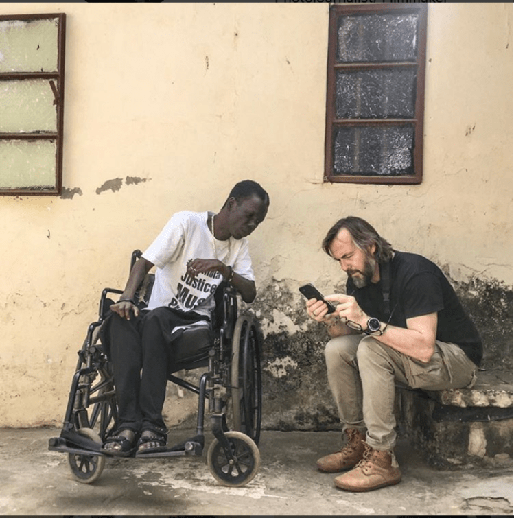 Jason Florio, with Yusepha Mbye, who was shot in the back by security forces in 2000 student protest - making #Portraits4PositiveChange #Gambia - image, Gambia © Helen Jones-Florio
