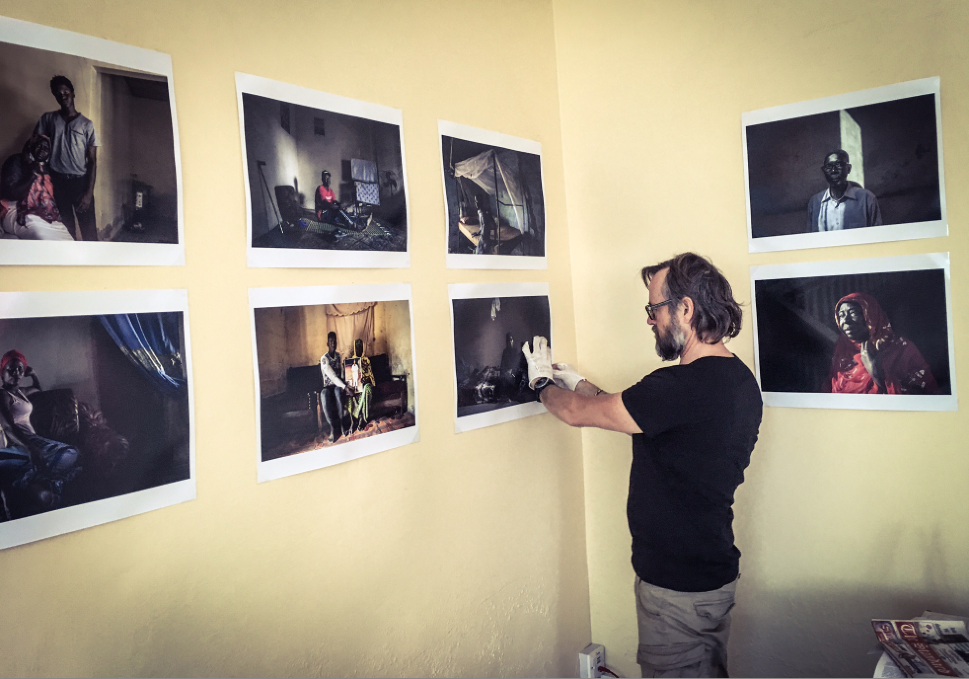 Photographer, Jason Florio, installing the exhibition 'Portraits to Remember' victims and resisters  © Helen Jones-Florio, the gambia