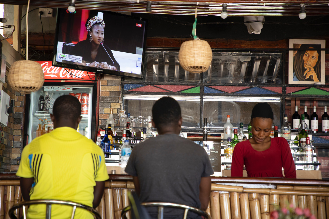 Young Gambian men watch the TRRC on TV in a bar as Fatou 'Toufah' Jallow testifies, The Gambia. Image © Jason Florio