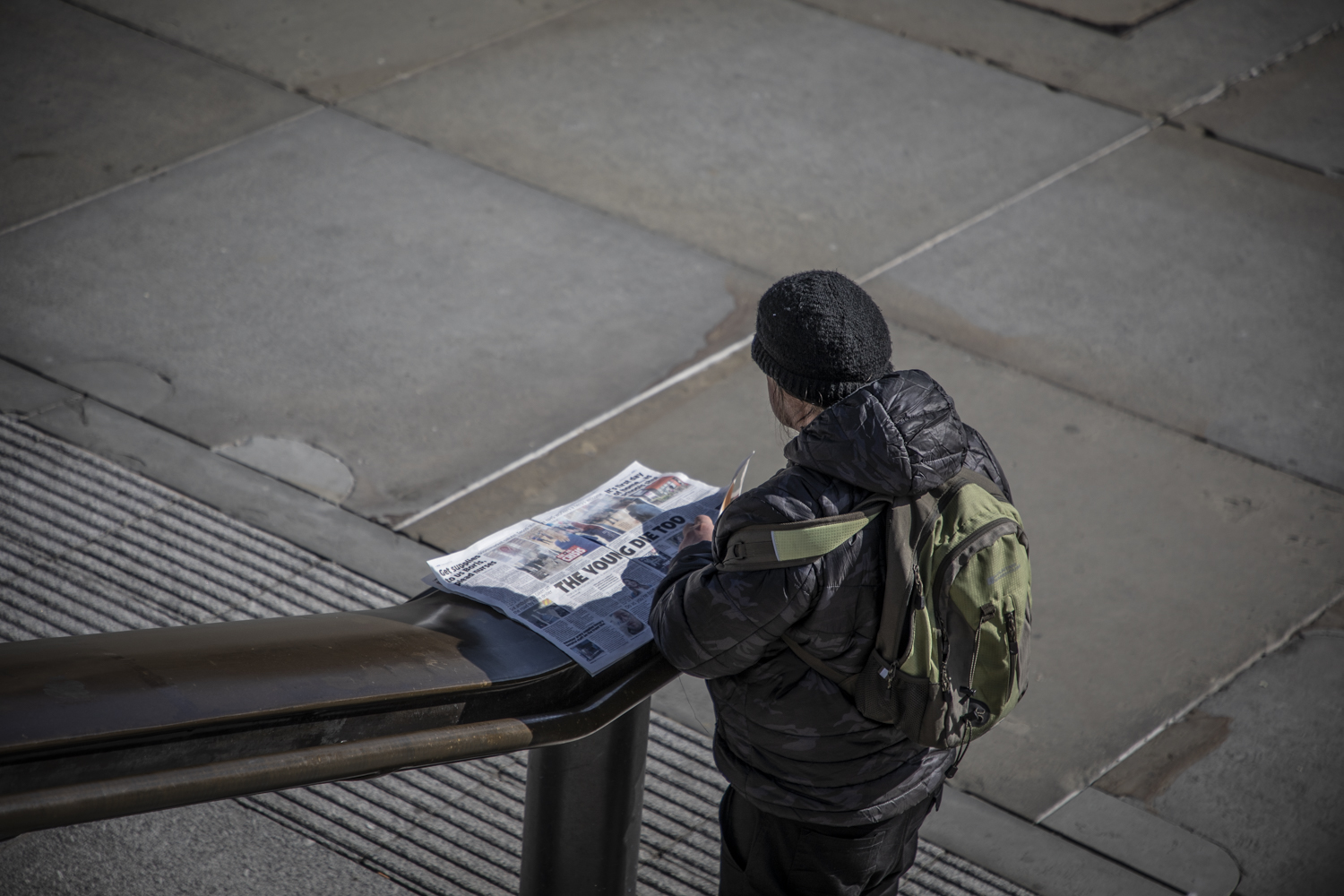 COVID 19 London lockdown. Homelessness-A lone man reads the newspaper in a deserted Trafalgar Square, London. Image © Jason Florio