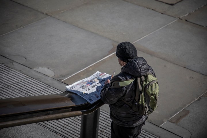 COVID 19 London lockdown. Homelessness-A lone man reads the newspaper in a deserted Trafalgar Square, London. Image © Jason Florio