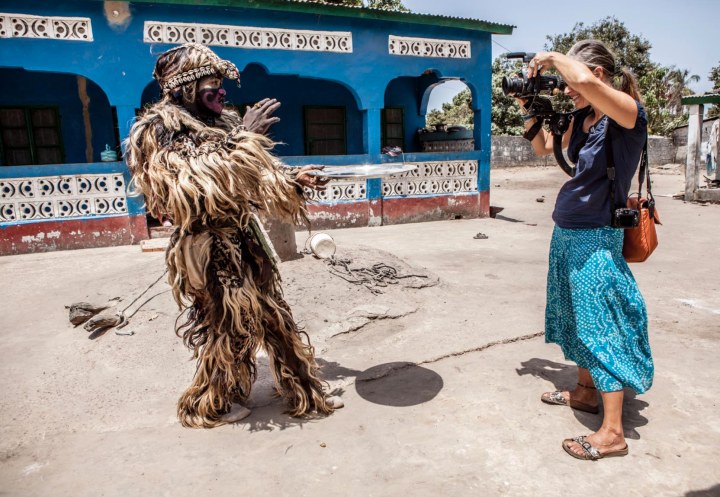 Photographer/videographer, Helen Jones-Florio, films the 'Zimba', one of The Gambia's many traditional masquerades, West Africa. Image © Jason Florio