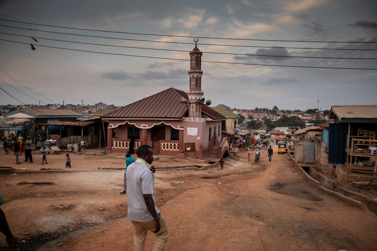 A man walks down the street towards the mosque, Kumasi, Ashanti Region, Ghana. Image ©Jason Florio