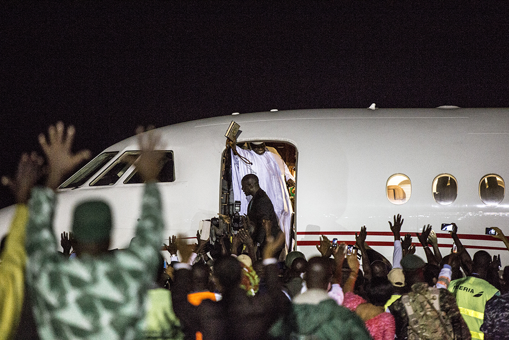 Ex President of The Gambia, Yahya Jammeh, waves goodbye to followers who came to see him off from Banjul airport as he leaves for exile in Equatorial Guinea. Image ©Jason Florio