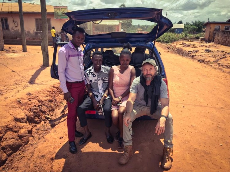 Photographer, and filmmaker, Jason Florio, with Isaac Mensah and his family, during the filming of 'I Cannot Bury My Father', Ghana. Image courtesy of Festus-Jackson Davies