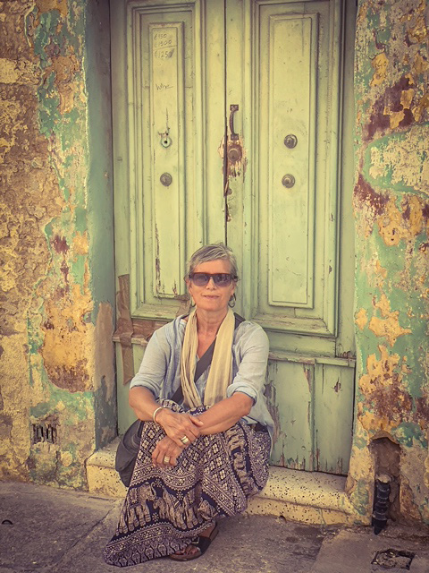 Helen Jones-Florio, sitting on the doorstep of an abandoned house, Malta. Image by Jason Florio