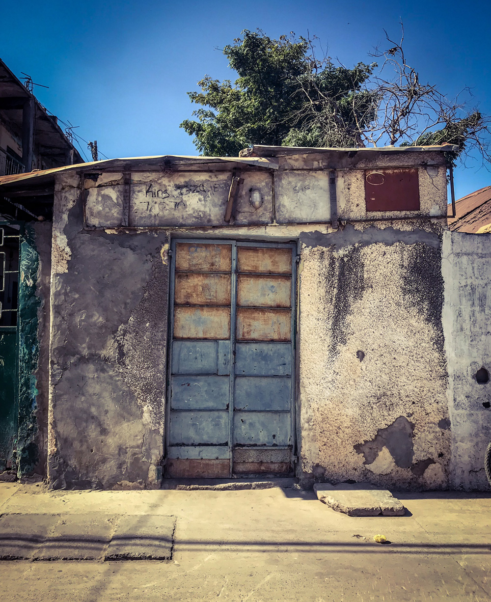#GambiaDoors - the (un)mundane doors and storefronts of The Gambia, West Africa. Shuttered storefront, Banjul. Image ©Helen Jones-Florio