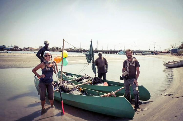 River Gambia expedition team standing by their two canoes on the banks of the River Gambia, Denton Bridge on the background. Jan 22nd 2013