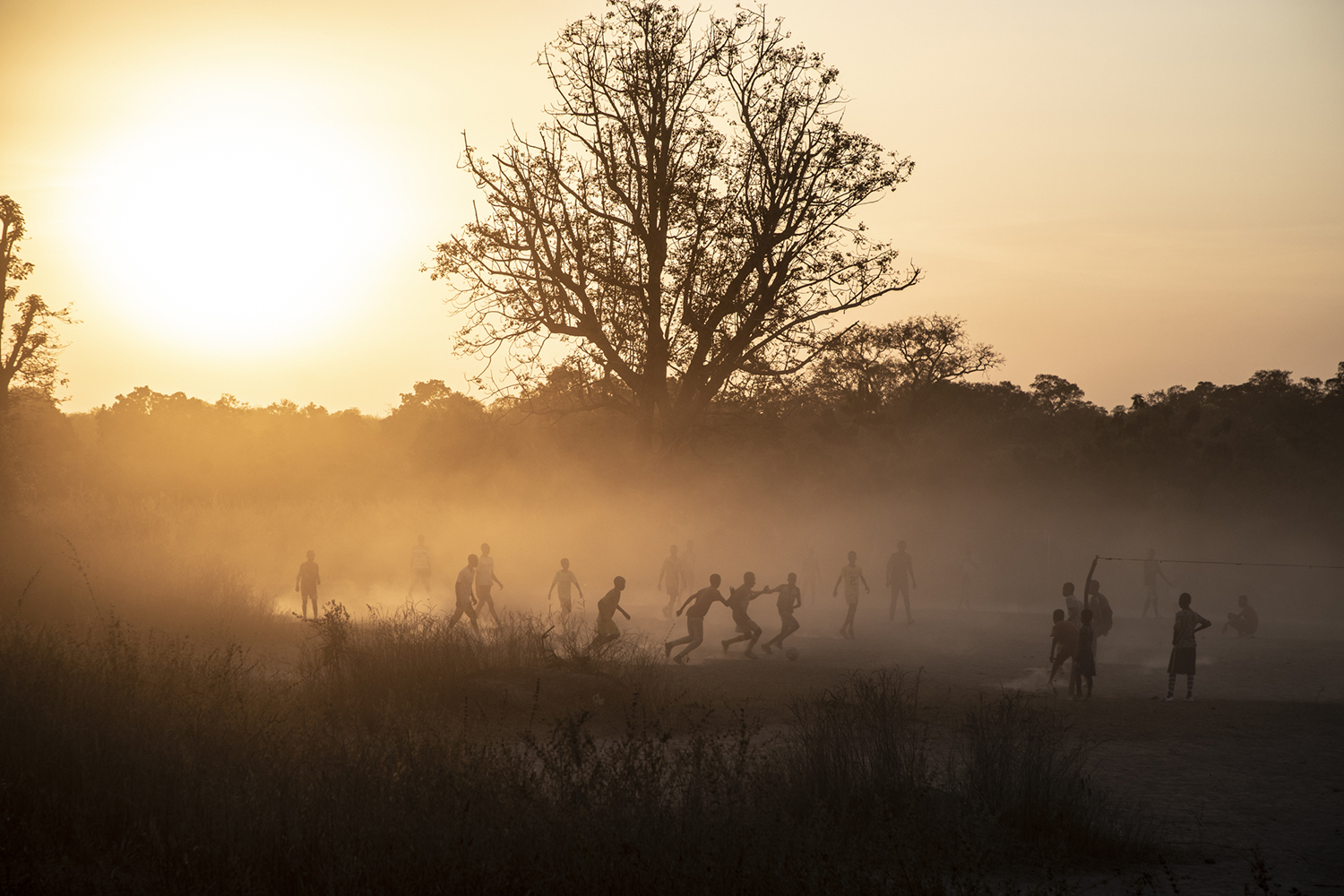 Boys playing football at dusk, rural area, The Gambia, West Africa. Image ©Jason Florio