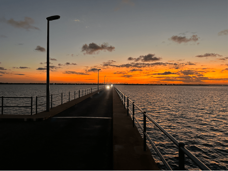 a bridge across a channel of water to Ilha Mozambique at sunset. Image ©Jason Florio