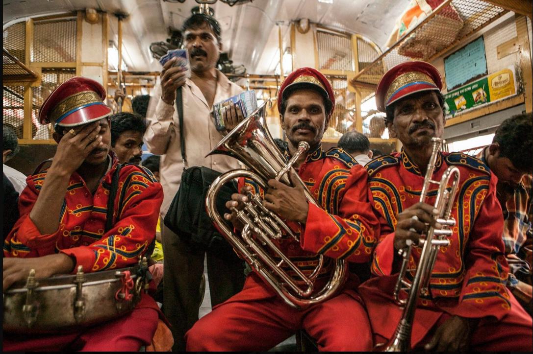 A brass band posing with their instruments on a train from Mumbai. Image © Jason Florio